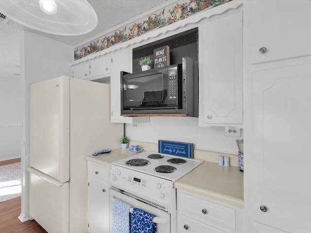 kitchen featuring white appliances, white cabinetry, and light countertops