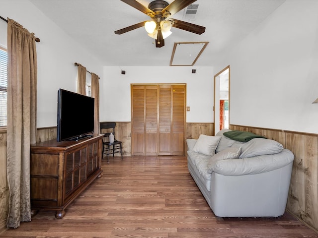 living area with plenty of natural light, wainscoting, and wooden walls