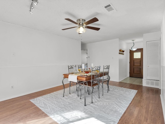 dining room featuring ceiling fan, wood finished floors, and visible vents