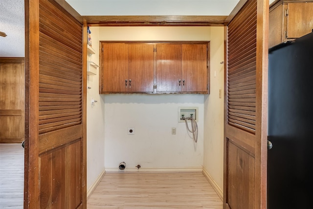 clothes washing area featuring cabinet space, baseboards, hookup for an electric dryer, light wood-type flooring, and washer hookup