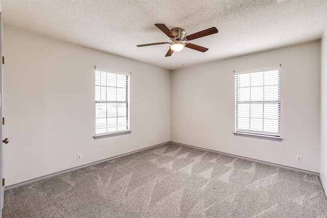 carpeted spare room featuring a textured ceiling and a ceiling fan