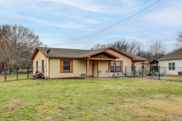 back of house featuring a gate, fence, and a lawn