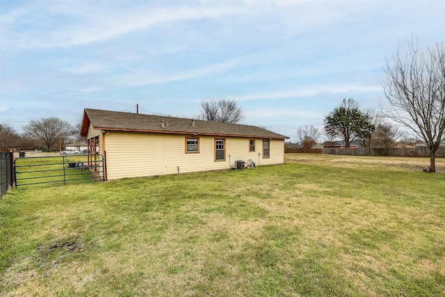 back of house with fence and a lawn