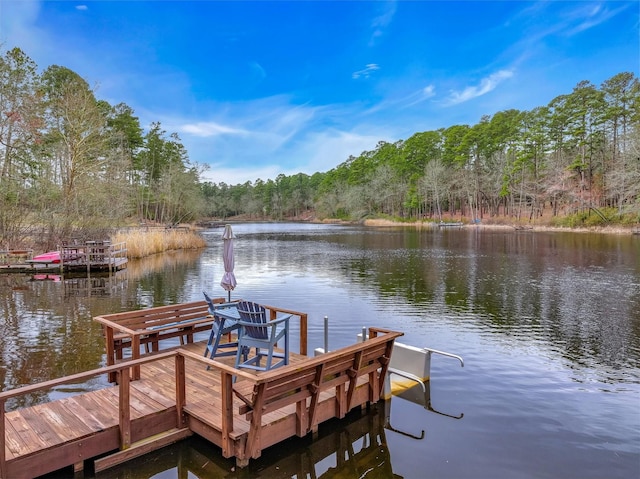 dock area featuring a water view and a wooded view