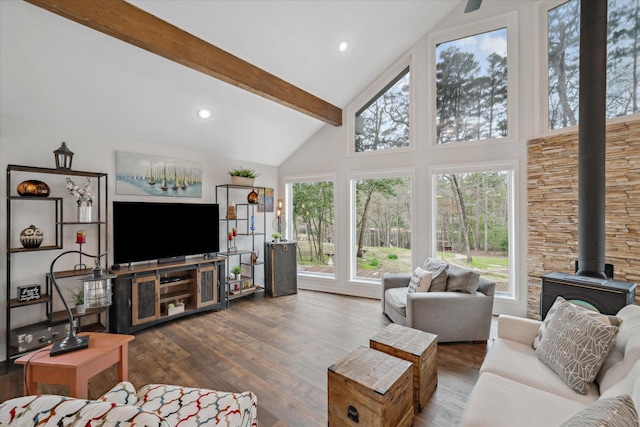 living room with beam ceiling, recessed lighting, a wood stove, wood finished floors, and high vaulted ceiling