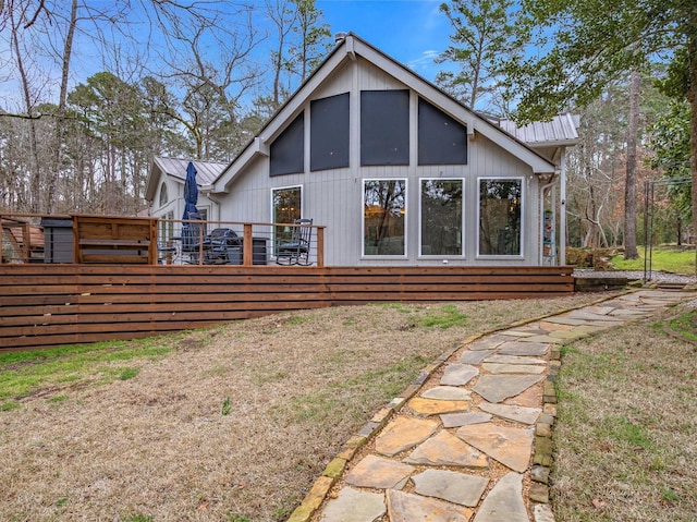 back of house with a yard, metal roof, and a wooden deck