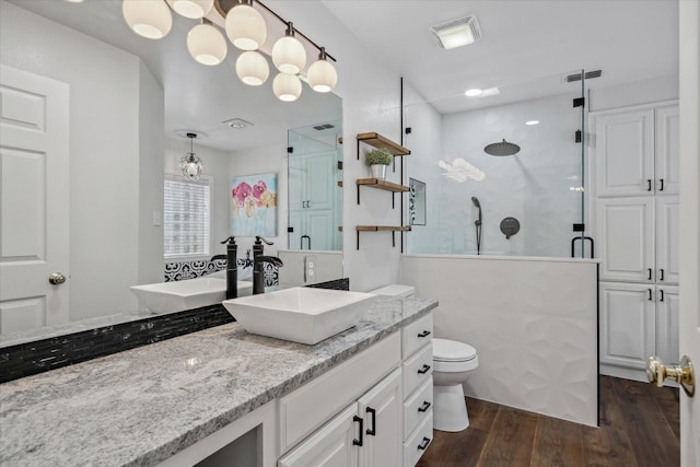 bathroom featuring a shower stall, visible vents, wood finished floors, and vanity