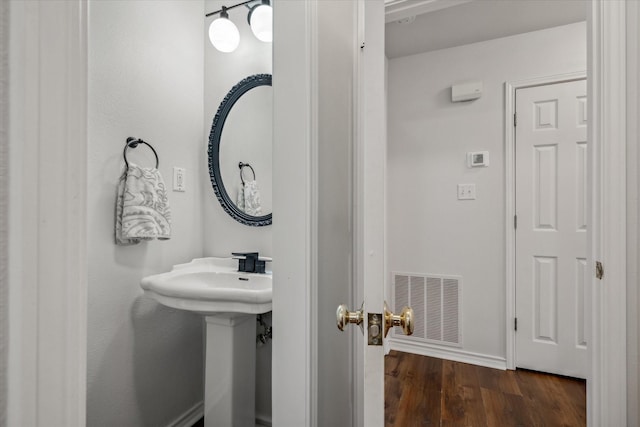 bathroom featuring visible vents, baseboards, and wood finished floors