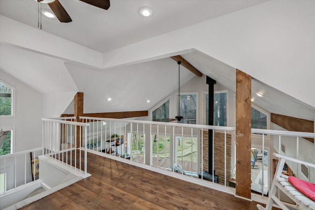 hall with lofted ceiling with beams, wood finished floors, and an upstairs landing