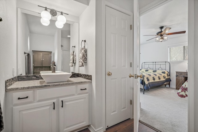 bathroom featuring ceiling fan, connected bathroom, vanity, and baseboards