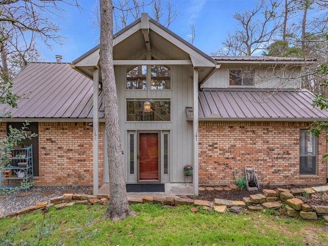 exterior space with metal roof, brick siding, and board and batten siding