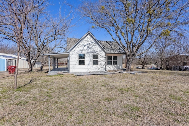 back of house with a carport and a yard