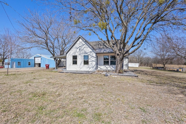 view of front facade with a front lawn and fence