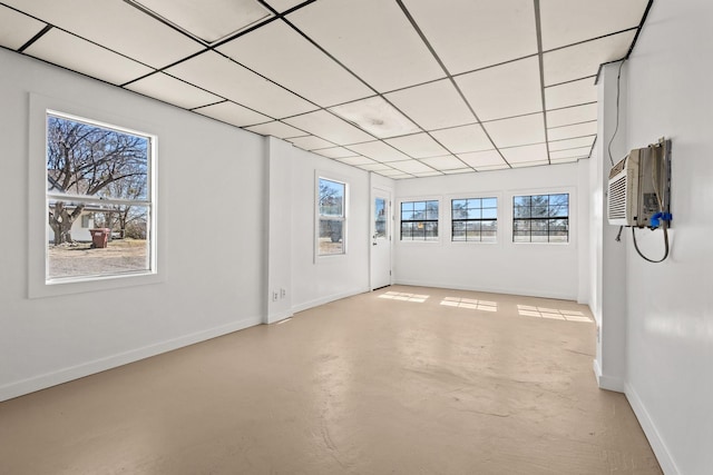 interior space featuring an AC wall unit, plenty of natural light, and a paneled ceiling