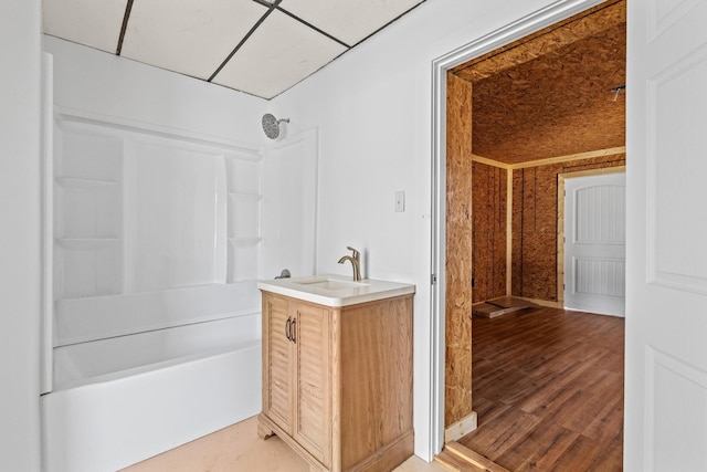 full bath with vanity, wood finished floors, and washtub / shower combination