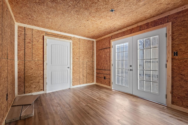 empty room with french doors, baseboards, and wood finished floors