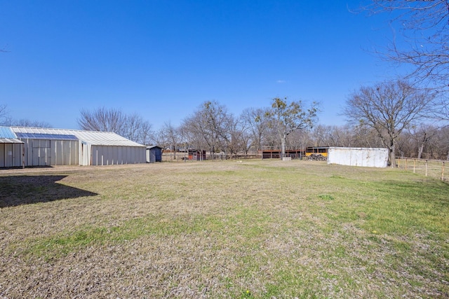 view of yard featuring fence and an outbuilding