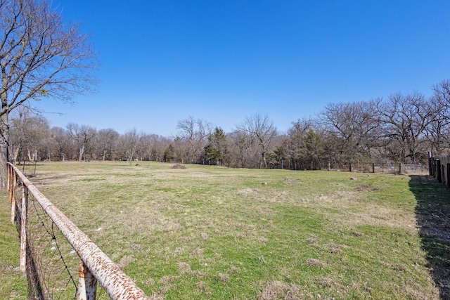 view of yard with a rural view and fence