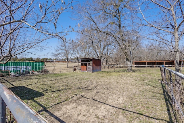 view of yard featuring an outbuilding, a pole building, a rural view, and fence