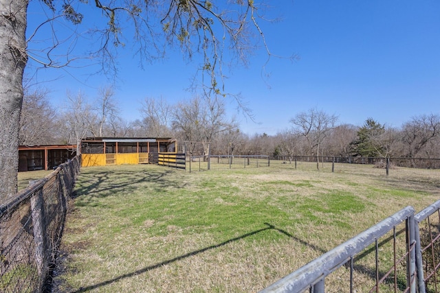 view of yard with a rural view, an outdoor structure, and an exterior structure