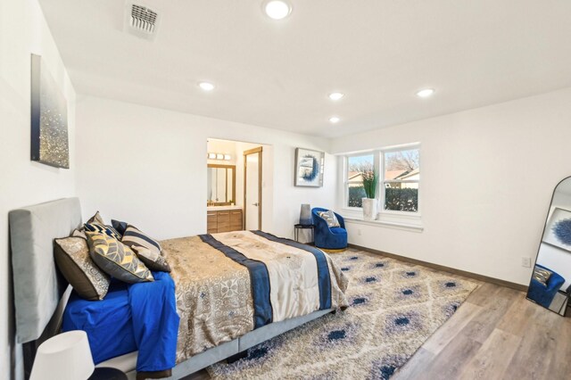 bedroom featuring recessed lighting, visible vents, ensuite bath, wood finished floors, and baseboards