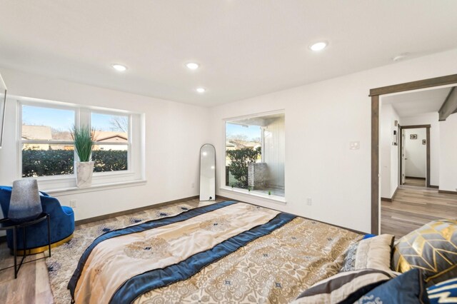 bedroom featuring baseboards, wood finished floors, and recessed lighting