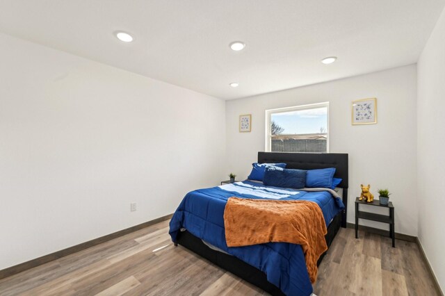 bedroom with light wood-type flooring, baseboards, and recessed lighting