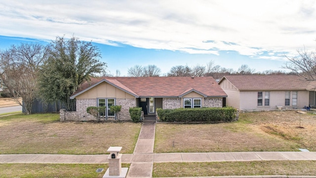 ranch-style house featuring a front yard and brick siding