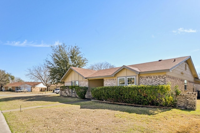 view of front of property with brick siding and a front lawn