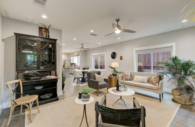 living area featuring ceiling fan, wood finished floors, visible vents, and recessed lighting