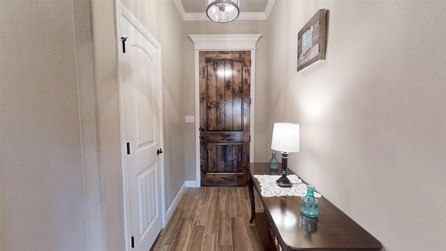 entryway with crown molding, baseboards, and wood finished floors