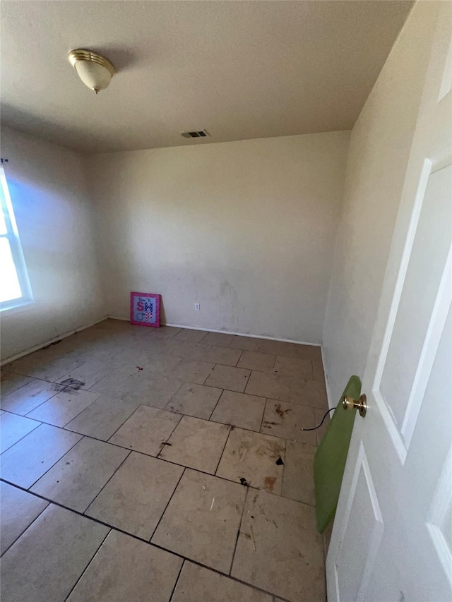 spare room with tile patterned flooring and visible vents