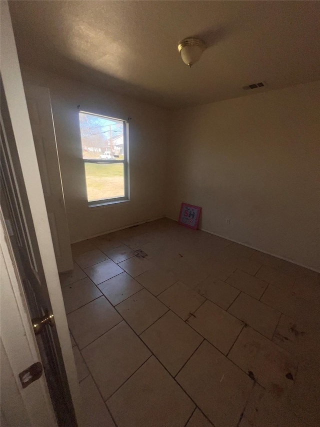 unfurnished room with visible vents