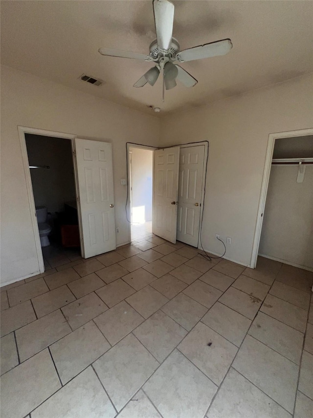 unfurnished bedroom featuring ensuite bathroom, visible vents, and a ceiling fan