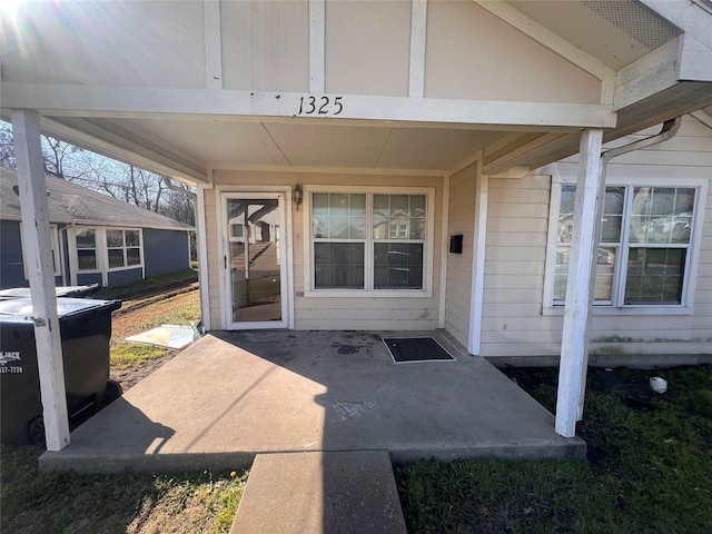 view of exterior entry with a patio