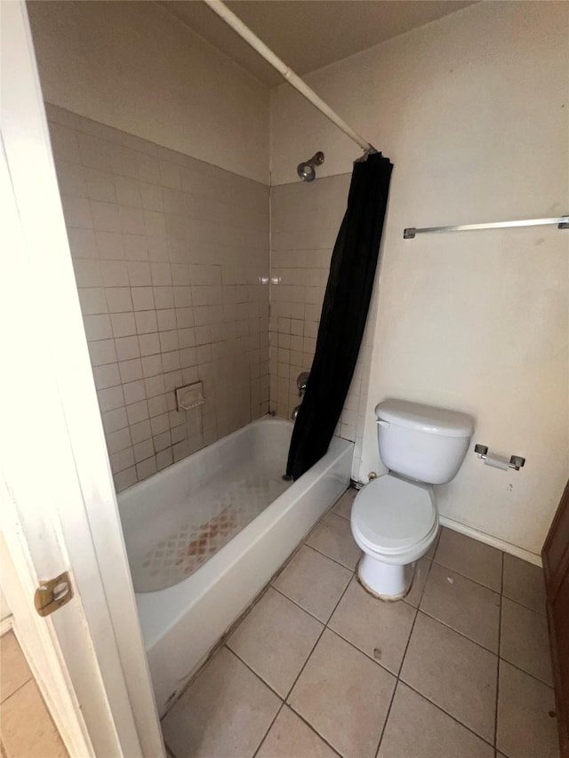 full bathroom featuring shower / bath combination with curtain, tile patterned flooring, toilet, and baseboards