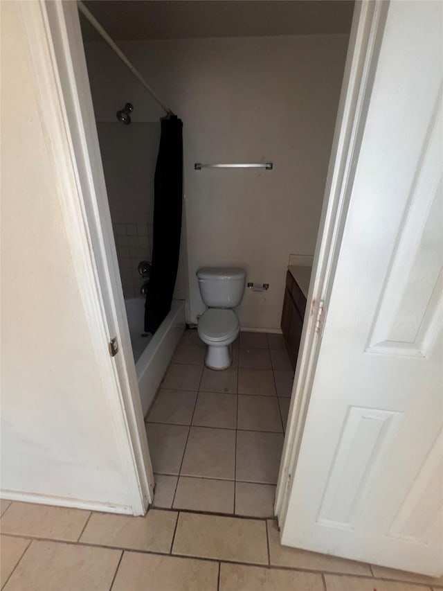 bathroom with shower / bath combination with curtain, vanity, tile patterned flooring, and toilet