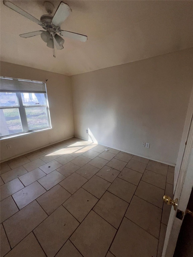 empty room with tile patterned flooring and a ceiling fan