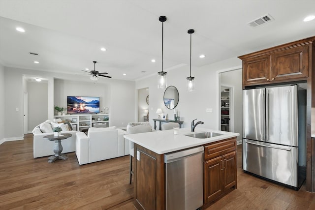 kitchen featuring dark wood finished floors, stainless steel appliances, recessed lighting, visible vents, and a sink