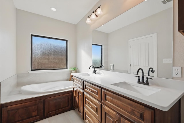 bathroom with double vanity, visible vents, tile patterned floors, a garden tub, and a sink