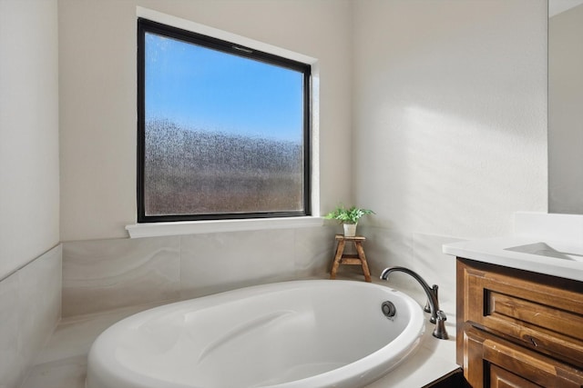 bathroom with a garden tub and vanity