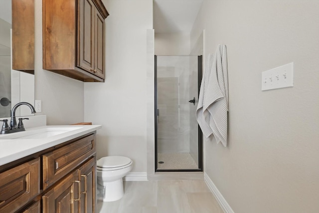 full bathroom with toilet, a shower stall, vanity, and baseboards