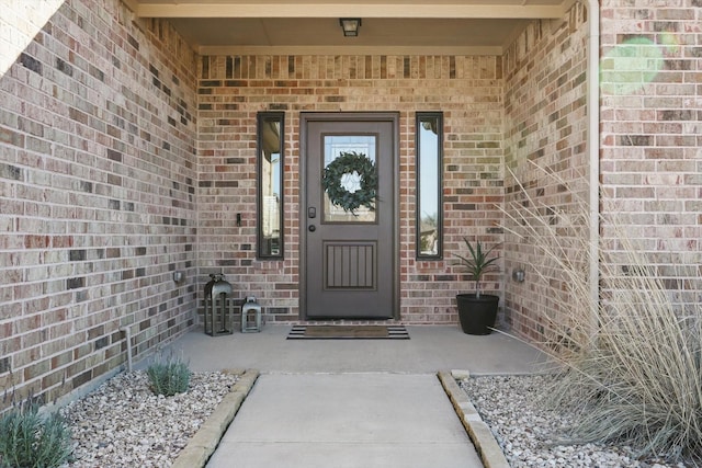 entrance to property featuring brick siding