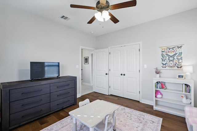 bedroom with dark wood-style floors, baseboards, visible vents, and a closet