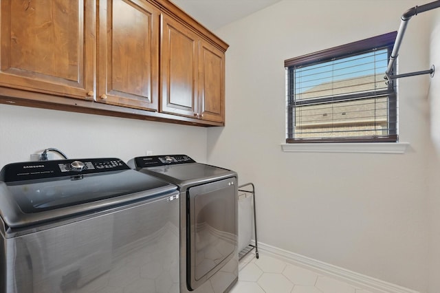 laundry room with cabinet space, baseboards, and washing machine and clothes dryer