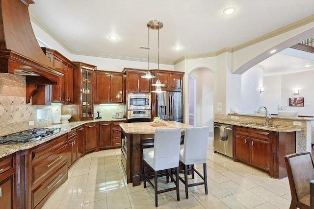 kitchen with arched walkways, a sink, appliances with stainless steel finishes, custom exhaust hood, and crown molding