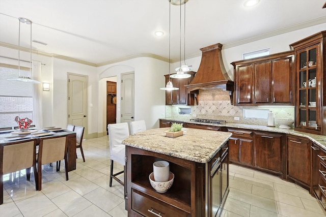 kitchen with open shelves, tasteful backsplash, visible vents, ornamental molding, and premium range hood