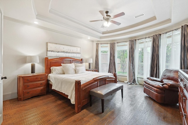 bedroom featuring a raised ceiling, visible vents, and crown molding