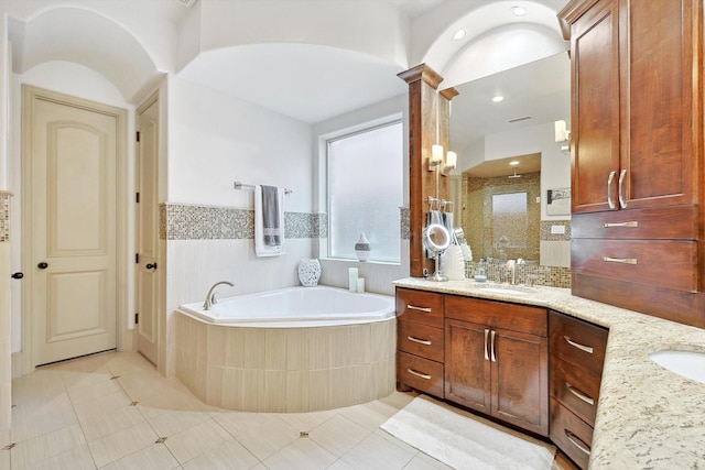 bathroom with ornate columns, a shower stall, a bath, and vanity