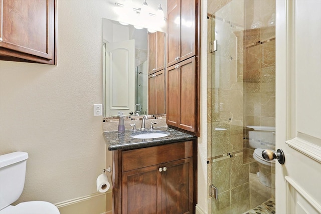 bathroom featuring toilet, a stall shower, and vanity